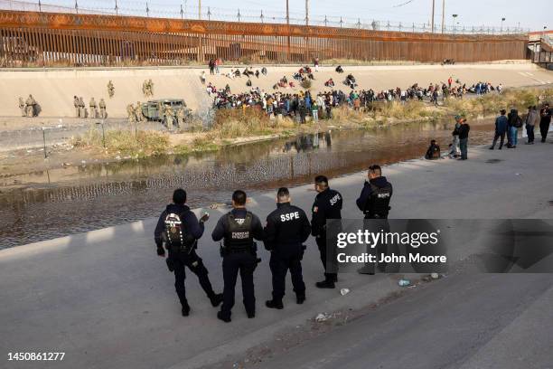 Mexican police observe as Texas National Guard troops block immigrants from entering a high-traffic illegal border crossing area along Rio Grande in...