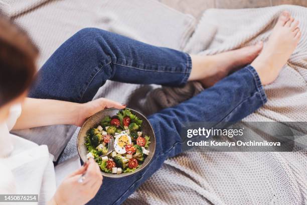 healthy vegetarian dinner. woman in jeans and warm sweater holding bowl with fresh salad, avocado, grains, beans, roasted vegetables, close-up. superfood, clean eating, vegan, dieting food concept - arm made of vegetables stock pictures, royalty-free photos & images