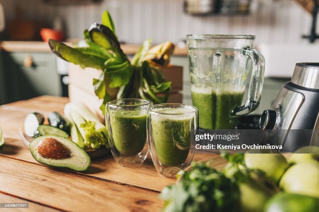 Healthy green smoothie with banana, spinach, avocado and chia seeds in a glass bottles on a rustic background