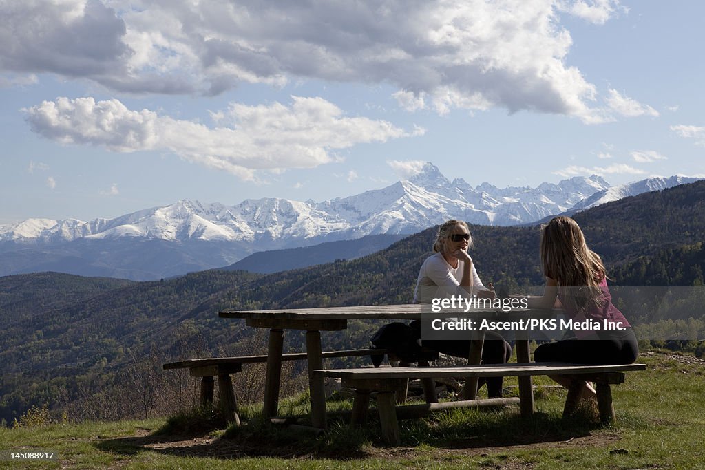 Mother and daughter converse across picnic table