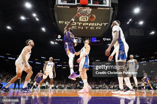 Deandre Ayton of the Phoenix Suns slam dunks the ball over Deni Avdija of the Washington Wizards during the second half of the NBA game at Footprint...