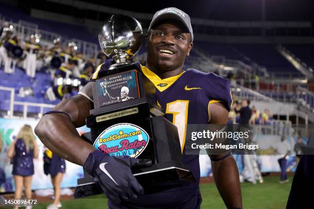 Jamal Hines of the Toledo Rockets celebrates with the trophy after defeating the Liberty Flames 21-19 in the RoofClaim.com Boca Raton Bowl game at...