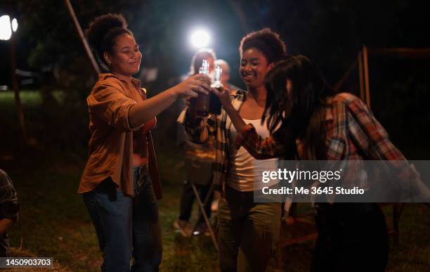 cheerful women having fun and having drinks together - night picnic stock pictures, royalty-free photos & images