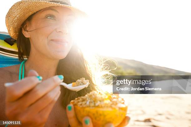 a female enjoying a day at the beach. - 30s woman eating stock pictures, royalty-free photos & images