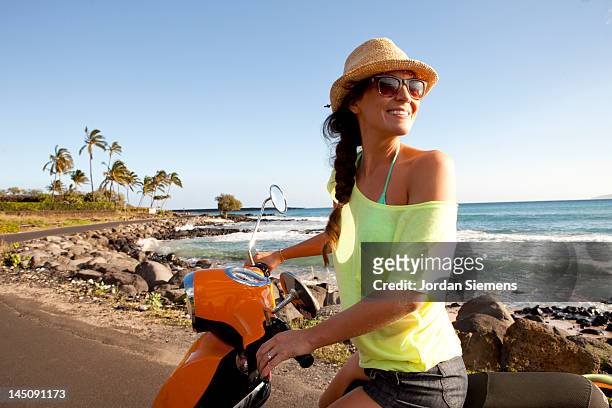 woman riding a scooter on a tropica island. - holiday scooter stock-fotos und bilder