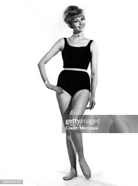 Reveille Fashions 1963: Jo Waring modelling a one piece swimming costume with a tape measure necklace and belt. 8th August 1963.