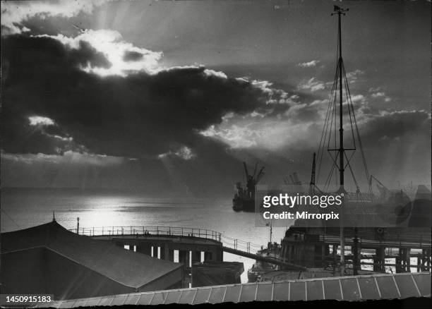 Dark clouds, pierced by the rays of a setting sun, help to make this dramatic picture of Hull's dockland, brought to a halt by the strike.