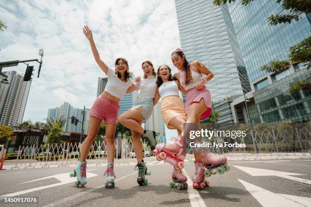 portrait of young filipino women roller skaters in the city - rollschuhlaufen stock-fotos und bilder