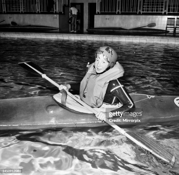 Young boy takes a canoe of a 10 feet high diving board at Bournemouth swimming pool. December 1969.