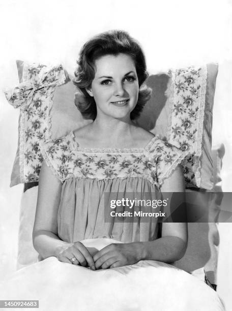Roma Reeves wearing nightdress sitting up on the bed. 31st August 1961.