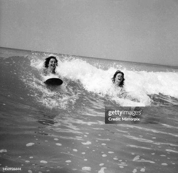 Women body boarding in the surf at Newquay June 1960.