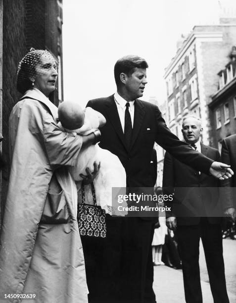 John F Kennedy after the christening of Anna Christina Radziwill who is held by godmother Countess Potocki. 5th June 1961.