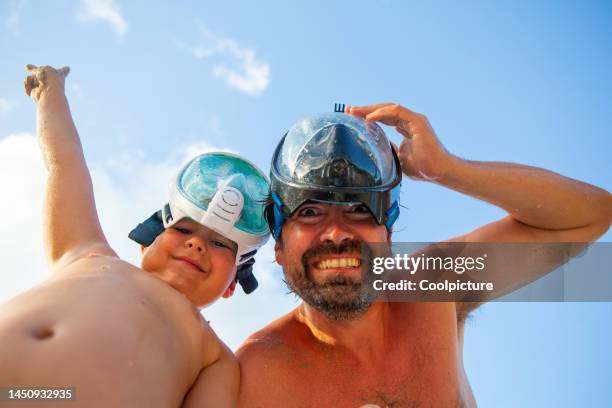 father and son enjoying swimming and having fun in the sea. - scuba diver stock pictures, royalty-free photos & images