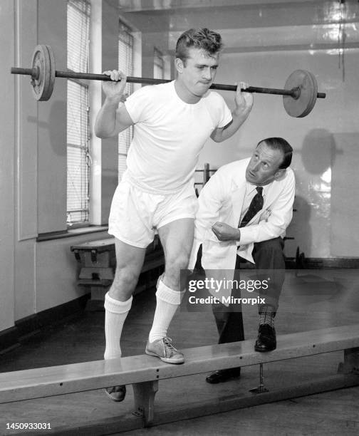 Arsenal physiotherapist Bertie Mee watches intently as Hendon outside right Terry Howard indulges in some gymnasium training, in an effort to get his...