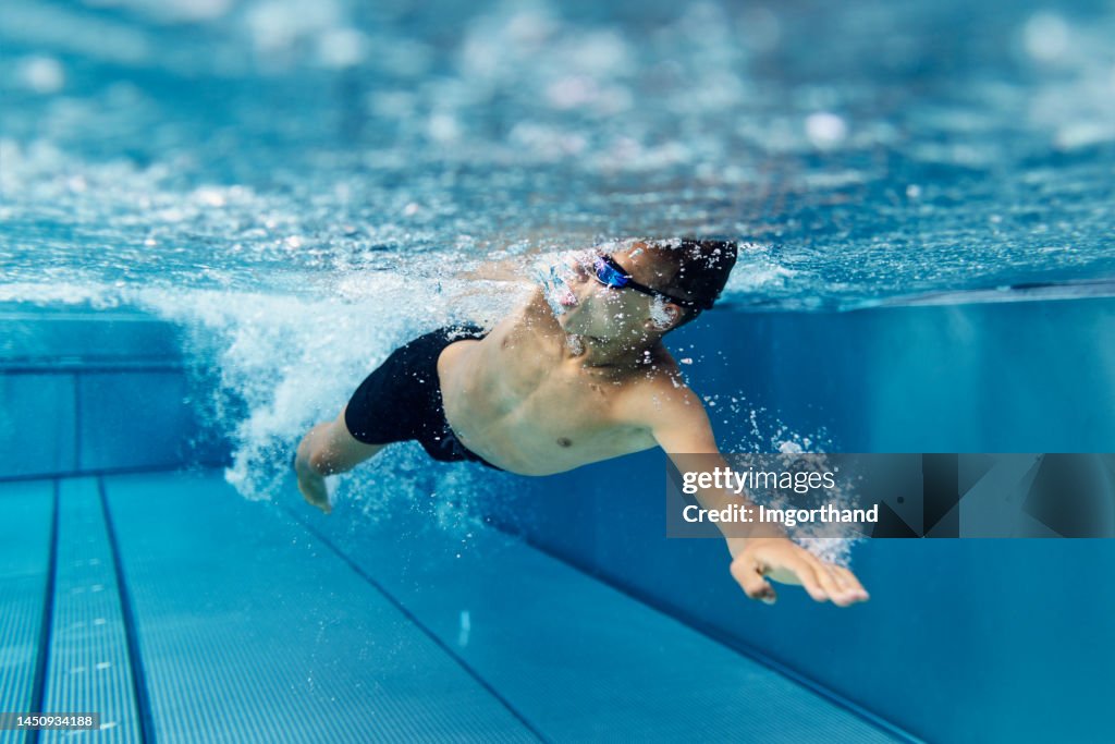 Teenager schwimmt im Pool
