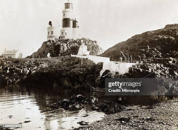 The keepers of the Skerries lighthouse take on provisions for Christmas from a Trinity House tenderNavigation Wales Anglesey Irish SeaDecember 1911.