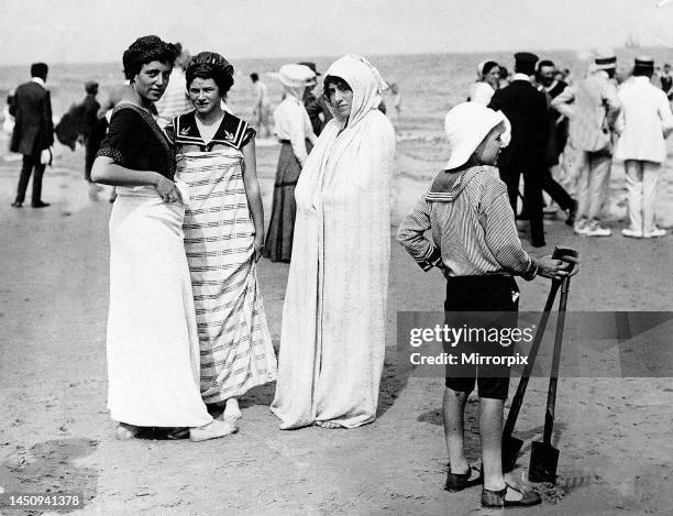 Bathers at Norderney Germany modelling fashion on a beach in 1911Wearing beach gear and bathing caps wrapped in towelsChild in floppy hat and sandals...