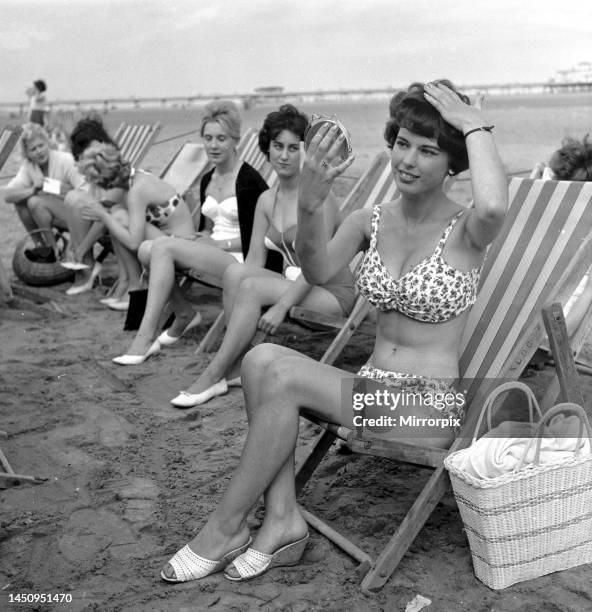 Beauty contest girls sitting in deck-chairs on the beach at Skegness putting on their make-up before the competition. 31st August 1960.