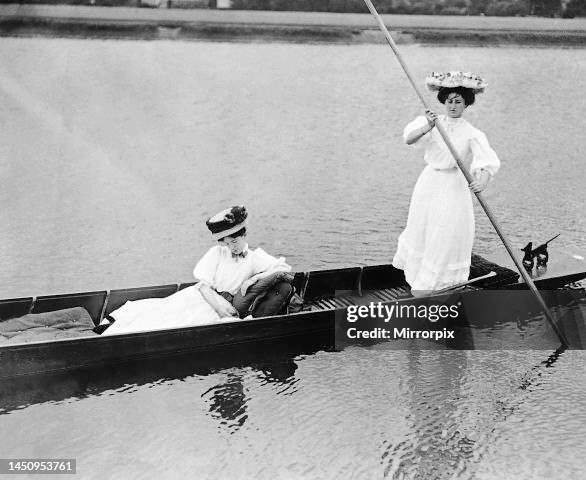 Fashion of 1919 with women in Edwardian dress punting on a lake circa 1919.