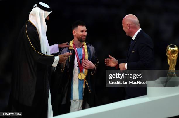 Lionel Messi of Argentina is presented a traditional black bisht robe by Sheikh Tamim bin Hamad Al Thani, Emir of Qatar, while Gianni Infantino,...