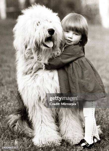 Little girl hugs her canine companion - an Old English Sheepdog. 22nd January 1962.