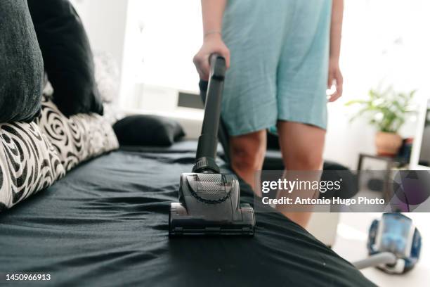 unrecognized woman cleaning the sofa with the vacuum cleaner. - saugen mund benutzen stock-fotos und bilder