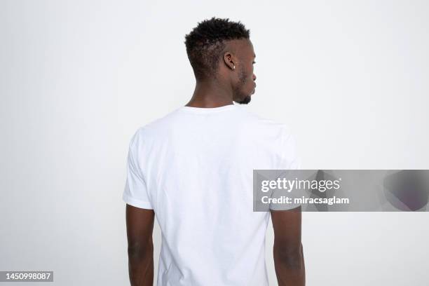 homem afro-americano em camiseta branca contra fundo branco. - lombo - fotografias e filmes do acervo