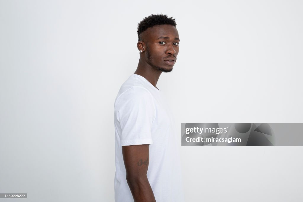 African-American man in white t-shirt against white background.