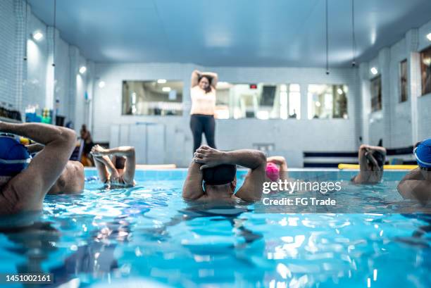 seniors stretching at swimming pool - aquarobics stockfoto's en -beelden
