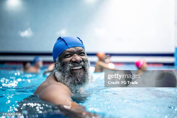 portrait of a senior man at swimming pool - aquarobics stockfoto's en -beelden