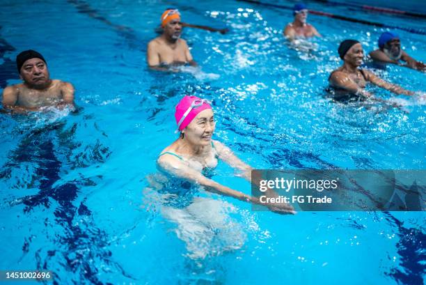 senior people exercising at swimming pool - aqua aerobics stock pictures, royalty-free photos & images