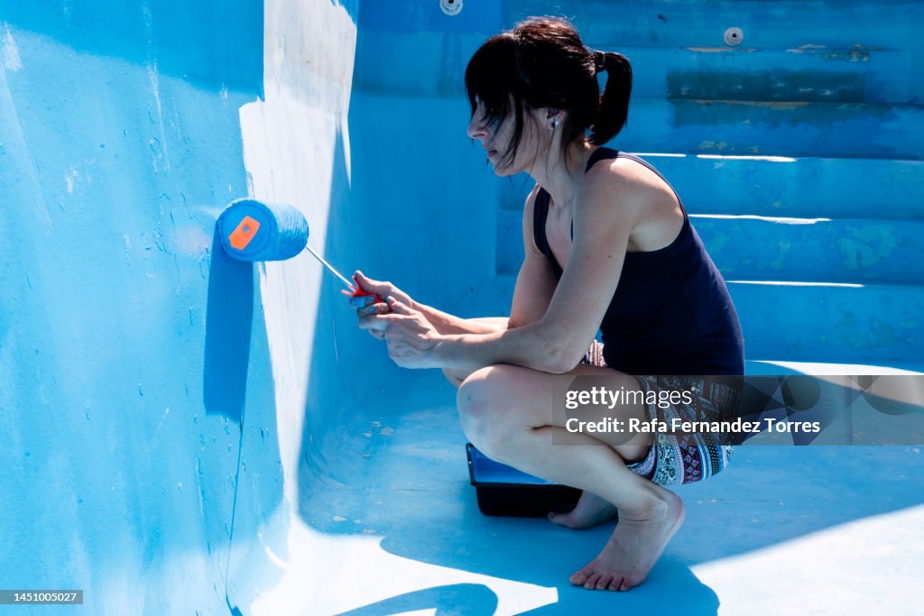 Woman painting the swimming pool
