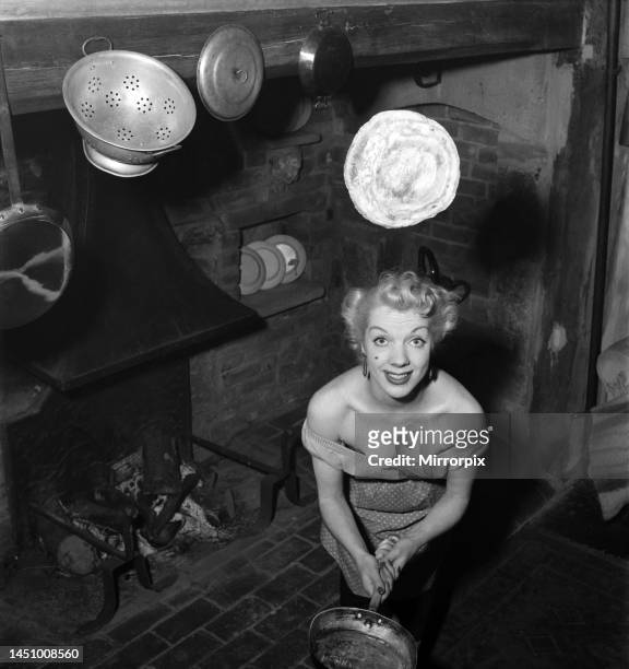 Wife of Richard Heane tossing a pancake on Shrove Tuesday. February 1951.