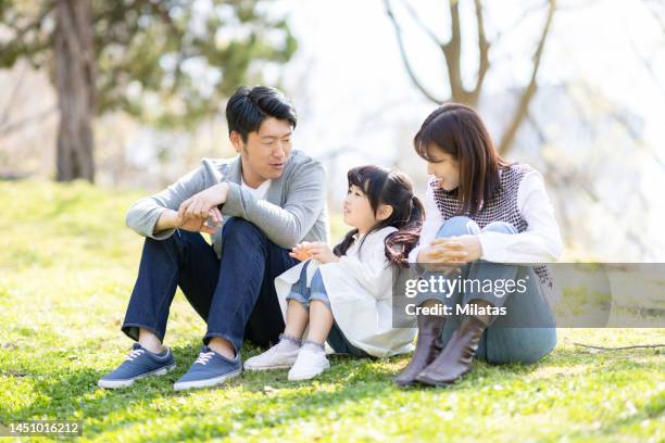 family relaxing in the park - exclusivamente japonés fotografías e imágenes de stock