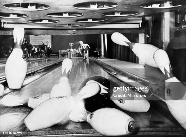 Year old dancer and singer Vicki Lane finds that Ten Pin Bowling is the ideal way to keep her figure trim. This picture was taken looking through the...