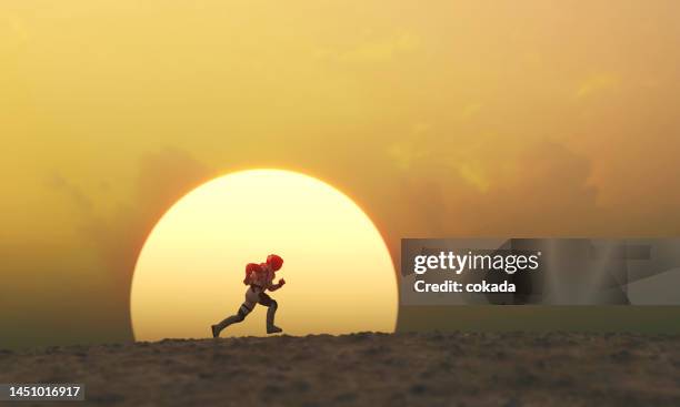 astronauta corriendo durante la puesta de sol en un planeta remoto - fugitive fotografías e imágenes de stock