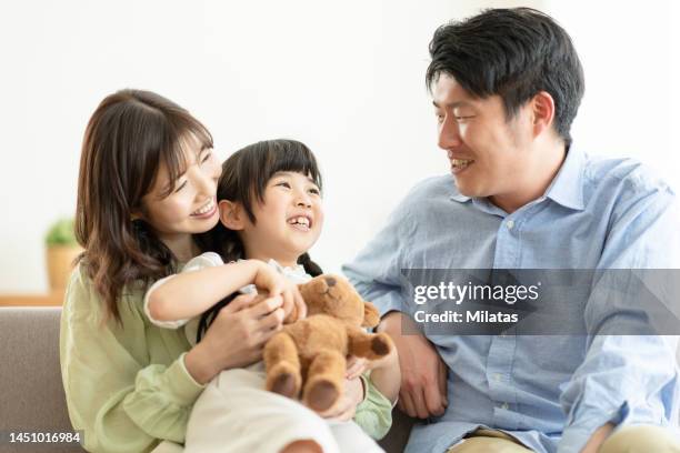 portrait of a family sitting on the couch - exclusivamente japonés fotografías e imágenes de stock