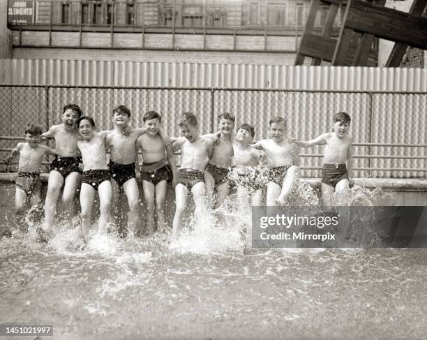 Boys kick up water in a swimming pool during the summer of 1951.