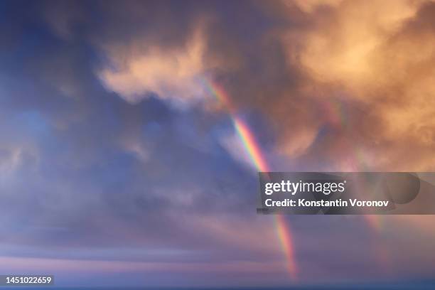 rainbow over dramatic sky background - rainbow sky stock-fotos und bilder