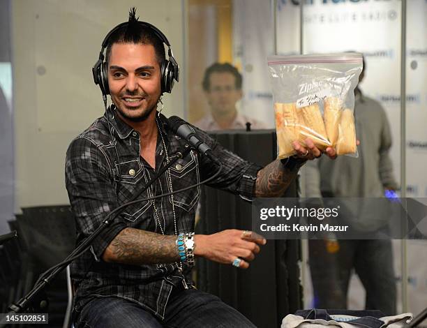 SiriusXM host Jose Mangin gives Slash tamales on SiriusXM's Octane in the SiriusXM Studio on May 23, 2012 in New York City.