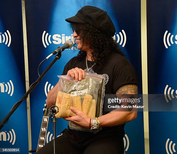 SiriusXM host Jose Mangin gives Slash tamales on SiriusXM's Octane in the SiriusXM Studio on May 23, 2012 in New York City.