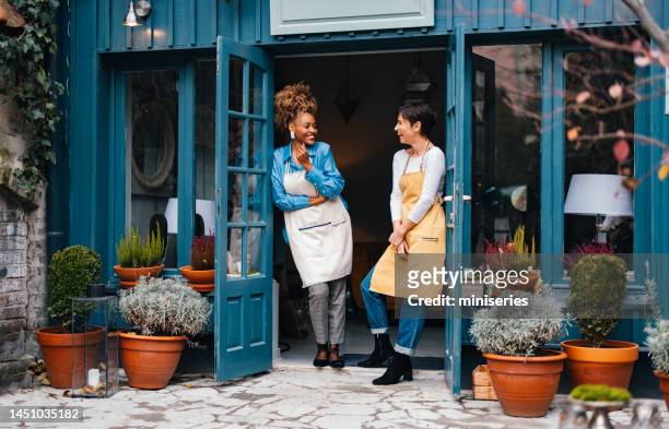 portrait of two smiling colleagues working together in a home decor store - small business stock pictures, royalty-free photos & images