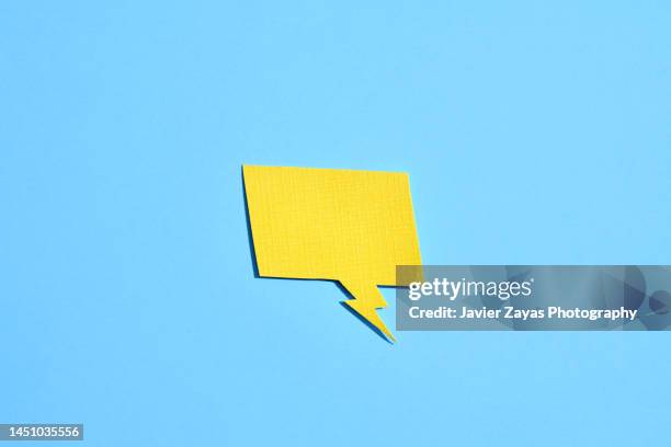 yellow comic bubble on blue background - kleverig stockfoto's en -beelden