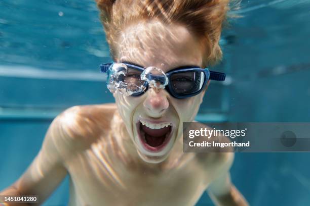 portrait of a crazy teenage boy shouting underwater in the swimming pool - children shouting stock pictures, royalty-free photos & images