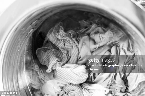 close-up of clothes in a washing machine - whitewashed photos et images de collection