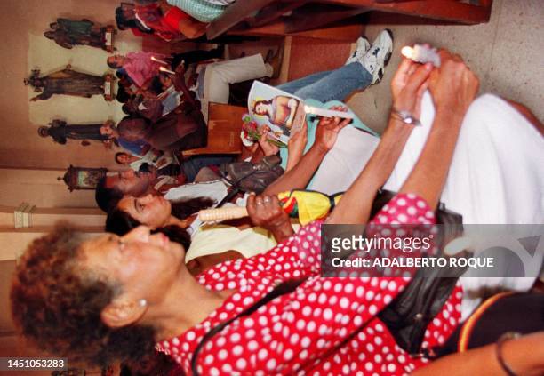 Devotees to the Virgin of Santa Barbara pray in the church of the same name in Havana 04 December to mark the day dedicated to her. Cubans of African...