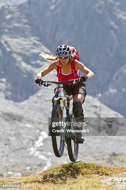 france, dauphine, vaujany, female mountain biker jumping - bicycle stunt stock pictures, royalty-free photos & images