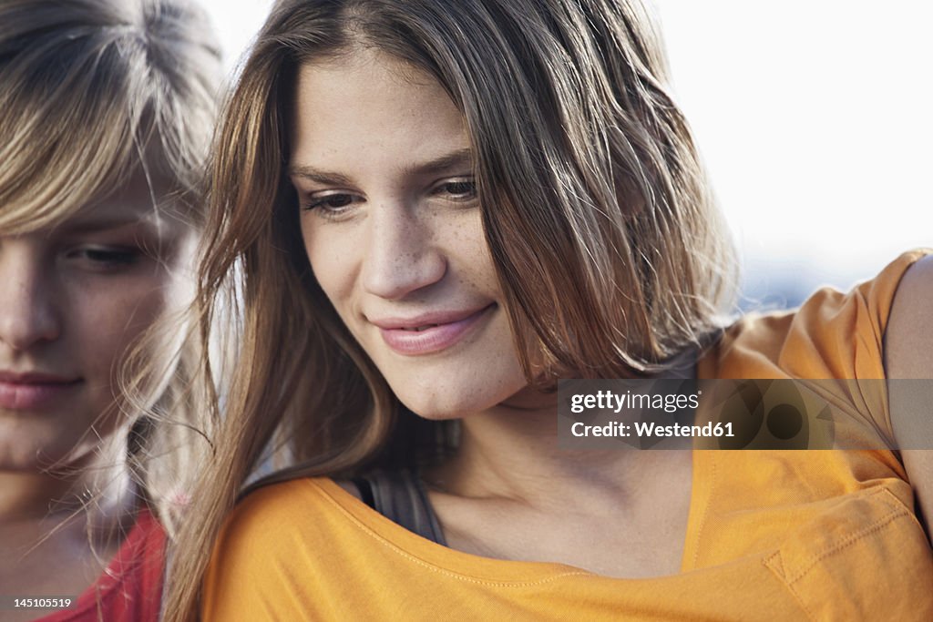 Germany, Cologne, Young woman looking down, smiling