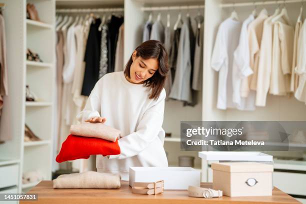 clothes shop and showroom. concentrated female working in a shop store, packing clothes - butiksinvigning bildbanksfoton och bilder