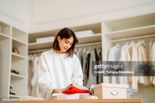 season clothes change in a wardrobe. calm woman change and arranging clothes for the new season - arranjo imagens e fotografias de stock